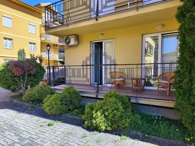 a yellow building with a balcony with chairs on it at Apartman Leone Vrnjačka Banja in Vrnjačka Banja