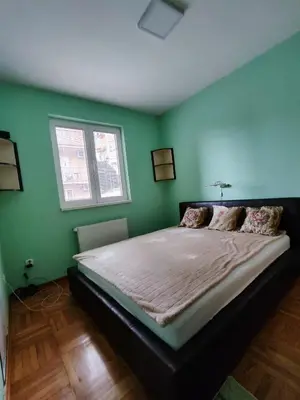 a bedroom with a large bed with green walls at Apartman Leone Vrnjačka Banja in Vrnjačka Banja