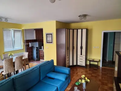 a living room with a blue couch and a table at Apartman Leone Vrnjačka Banja in Vrnjačka Banja