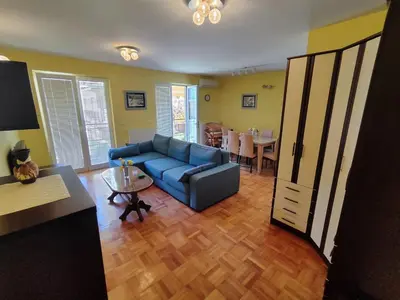 a living room with a blue couch and a table at Apartman Leone Vrnjačka Banja in Vrnjačka Banja