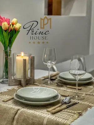 a table with a candle and plates and wine glasses at Princ house in Leskovac
