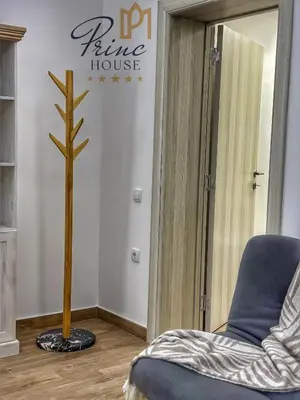 a living room with a blue chair and a tree at Princ house in Leskovac