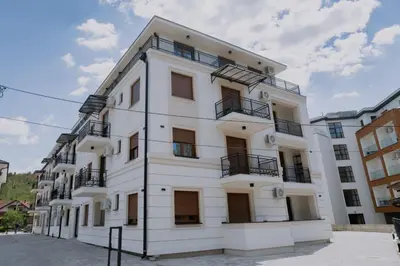 a white building with balconies on a street at Vrnjacka Renesansa Promenada in Vrnjačka Banja