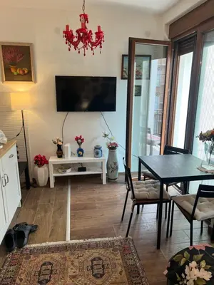 a living room with a table and a television at Vrnjacka Renesansa Promenada in Vrnjačka Banja