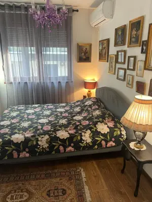 a bedroom with a bed with a floral bedspread at Vrnjacka Renesansa Promenada in Vrnjačka Banja