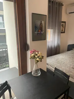 a table with a vase of flowers on top of it at Vrnjacka Renesansa Promenada in Vrnjačka Banja