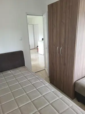 a bedroom with a bed and a wooden cabinet at Apartment Pavlović in Soko Banja
