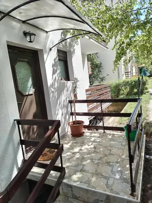 a patio with two benches and an umbrella at Apartman Tina in Soko Banja