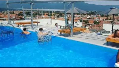 a pool with people sitting in chairs in the water at Elegant Lux in Vrnjci