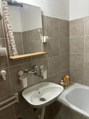 a bathroom with a sink and a mirror and a tub at Apartman LENKA in Pirot