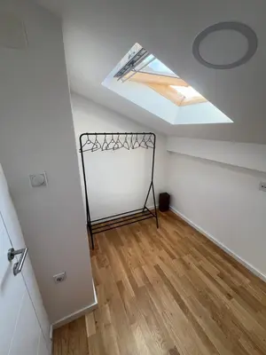 an attic room with a skylight and a bed at LiboroApartments in Niš