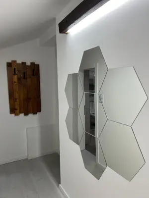 a room with a white wall with a mirror at LiboroApartments in Niš