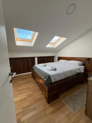 a bedroom with a bed and two skylights at LiboroApartments in Niš