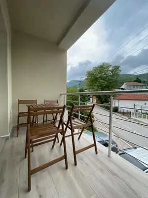 two chairs and a table on a balcony with a view at Apartmani Videnovic Sokobanja in Soko Banja