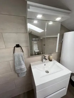 a bathroom with a white sink and a mirror at LiboroApartments in Niš