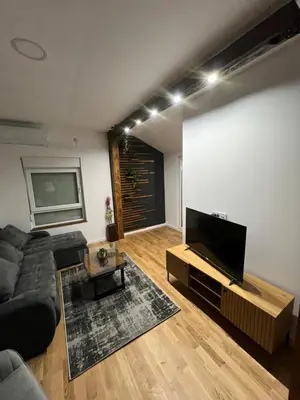 a living room with a couch and a flat screen tv at LiboroApartments in Niš