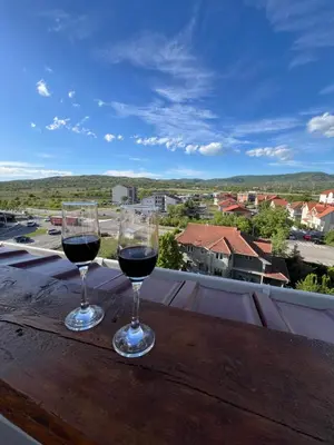 two glasses of wine sitting on a wooden table at LiboroApartments in Niš