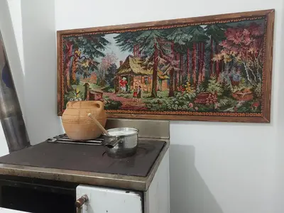 a tapestry hanging on a wall next to a stove at Smeštaj Gokčanica in Gokčanica