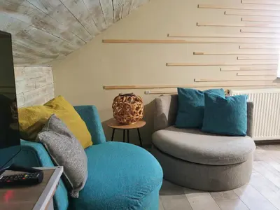a living room with a blue couch and a chair at URBAN Life STYLE in Zaječar