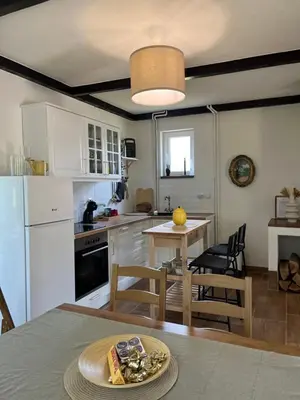 a kitchen with white appliances and a table and chairs at Villa Buena in Despotovac