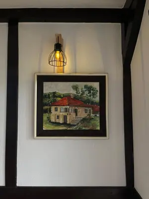 a painting of a house on a wall with a light at Villa Buena in Despotovac