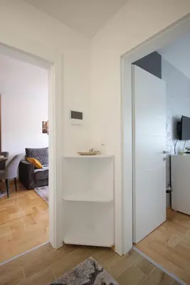 a living room with white walls and a sliding door at Apartman Zivic in Vrnjci