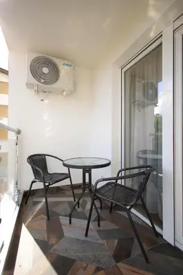 a table and chairs in a room with a fan at Apartman Zivic in Vrnjci