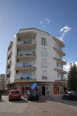 a tall building with cars parked in front of it at Apartman Zivic in Vrnjci