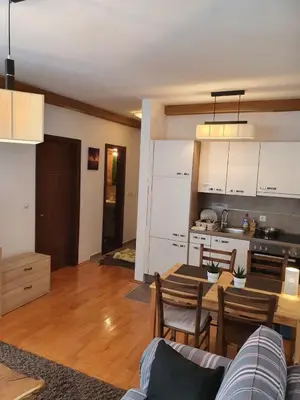 a kitchen and living room with a table and a dining room at APARTMENTS FOKA & SPA - 600m from Gondola ski lift in Kopaonik