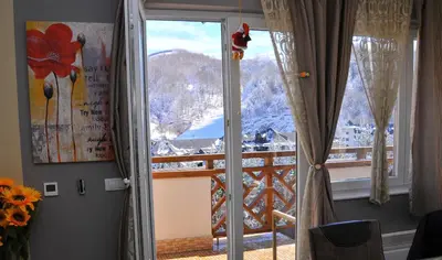 a room with a window with a view of a mountain at APARTMENTS FOKA & SPA - 600m from Gondola ski lift in Kopaonik