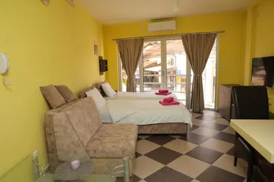 a bedroom with a bed and a couch and a chair at Studio Apartman Ad fines in Kuršumlija