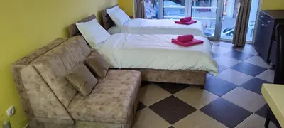 a hotel room with two beds and a couch at Studio Apartman Ad fines in Kuršumlija
