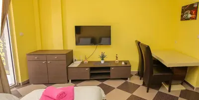 a yellow room with a desk and a desk sidx sidx sidx sidx sidx at Studio Apartman Ad fines in Kuršumlija