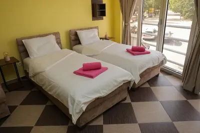 two beds in a room with red towels on them at Studio Apartman Ad fines in Kuršumlija