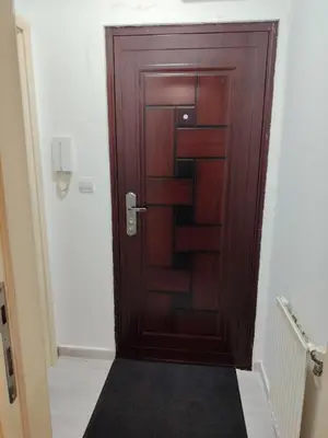 a wooden door in a hallway with a black rug at Nena Studio in Jagodina