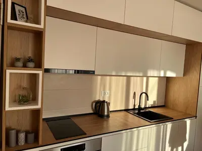 a kitchen with white cabinets and a sink at Prirodni Raj-Udoban Sokobanja Apartman in Soko Banja