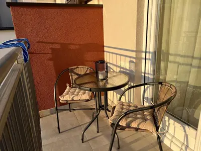 a small table and two chairs on a balcony at Prirodni Raj-Udoban Sokobanja Apartman in Soko Banja