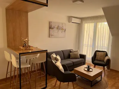 a living room with a couch and a table at Prirodni Raj-Udoban Sokobanja Apartman in Soko Banja