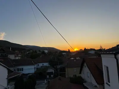 a sunset over the roofs of a town at Prirodni Raj-Udoban Sokobanja Apartman in Soko Banja