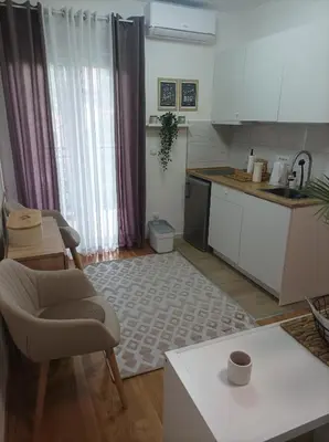 a kitchen with a couch and a chair and a table at Studio SIESTA in Vrnjačka Banja