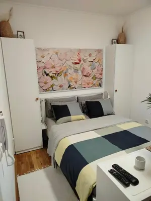 a bedroom with a bed with a painting on the wall at Studio SIESTA in Vrnjačka Banja