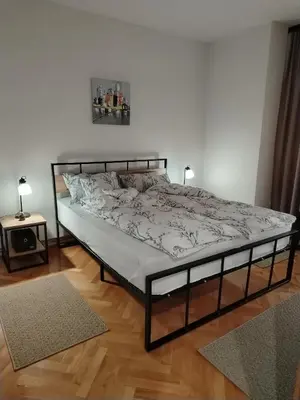 a bed in a white room with a bed frame at Balkan HOME in Kalna