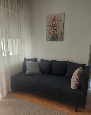 a blue couch in a living room with a painting at Balkan HOME in Kalna