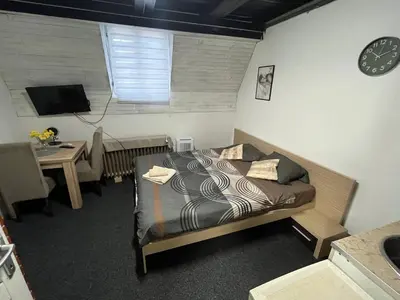 a bedroom with a bed and a table and a clock at Stan na dan Raška in Raška