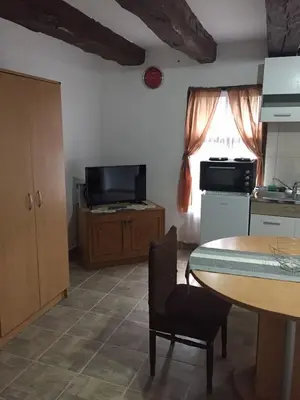 a kitchen with a table and a kitchen with a table and a dining room at Apartmani Nikola Dojkinci in Pirot