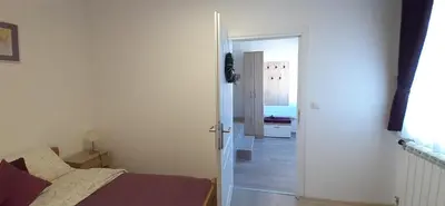 a bedroom with a bed and an open door at Apartments Villa Stars in Kopaonik
