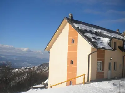 a building on top of a snow covered mountain at Apartments Villa Stars in Kopaonik