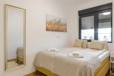 a bedroom with a bed with a large mirror at Apartmani Central 14 & Free parking garage in Vrnjačka Banja