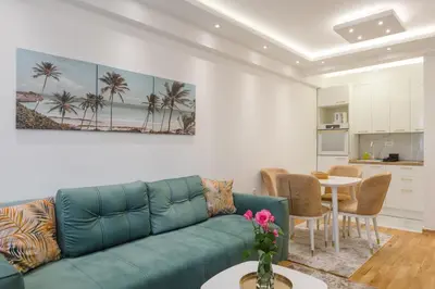 a living room with a blue couch and a table at Apartmani Central 14 & Free parking garage in Vrnjačka Banja