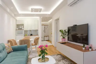 a living room with a blue couch and a tv at Apartmani Central 14 & Free parking garage in Vrnjačka Banja